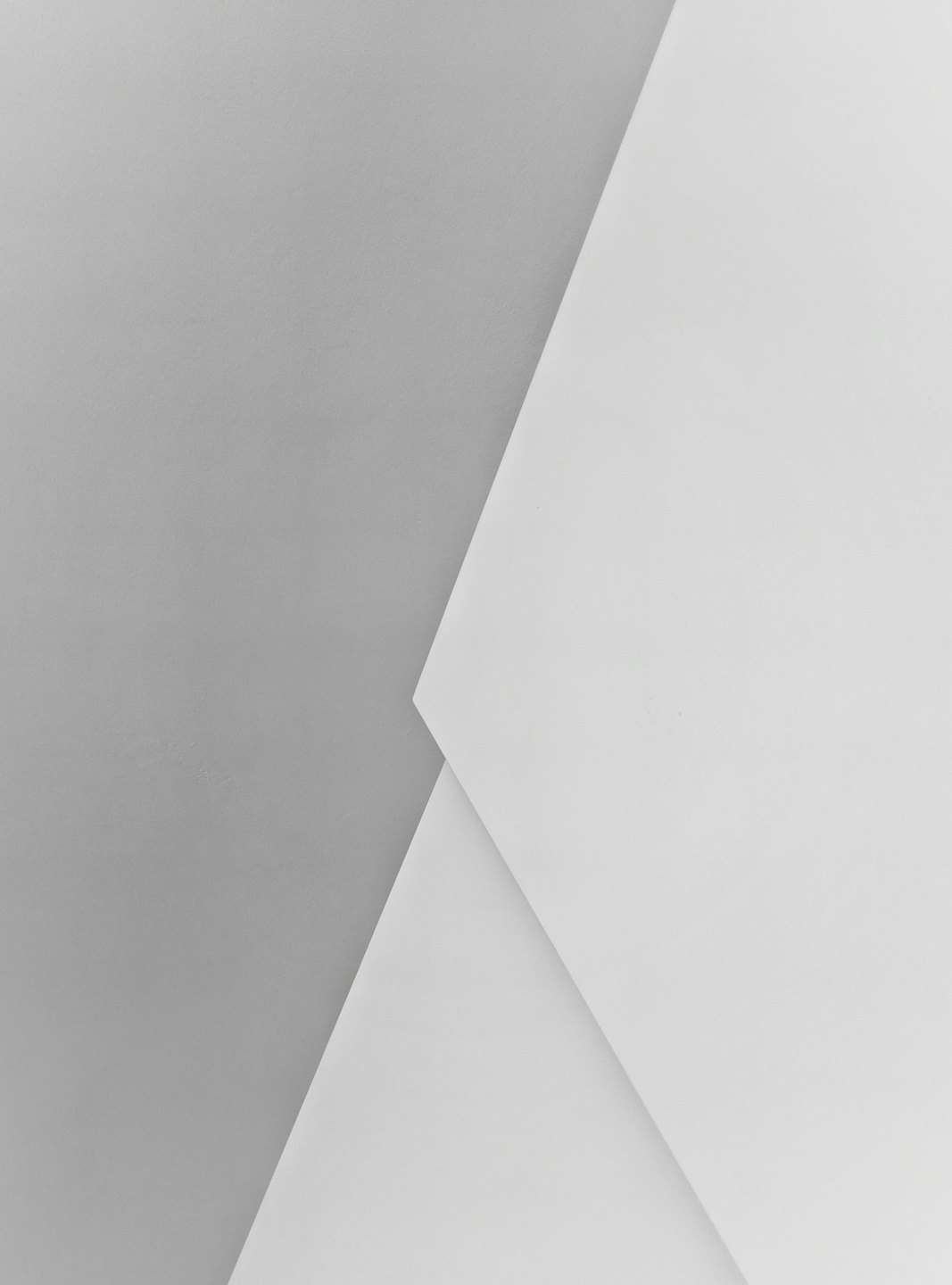 Geometric shapes formed by intersecting light gray and white planes.